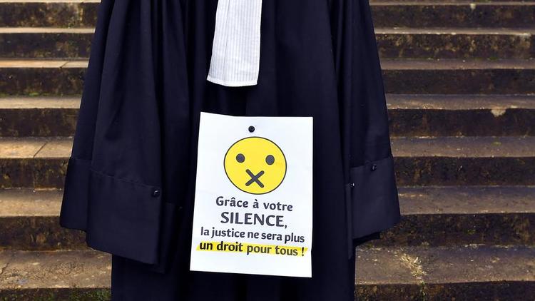 Une photo, prise le 17 janvier 2020, montre un panneau sur la robe d'un avocat devant le palais de justice de Bordeaux, lors d'une manifestation pour dénoncer la perte de leur régime de retraite. 