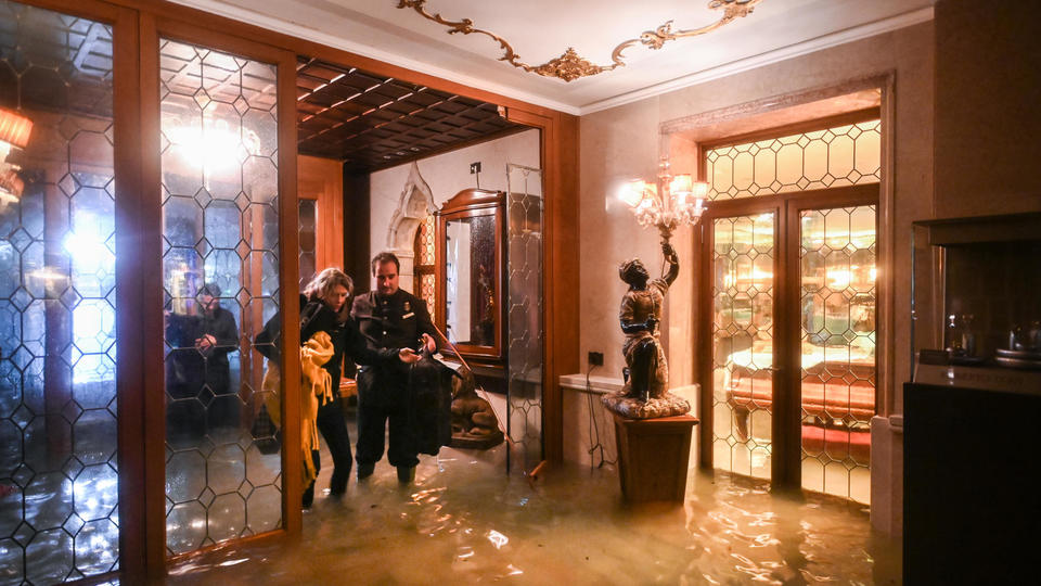 Des palaces centenaires ont été envahis par les eaux. Ici, un employé du Gritti Palace aide une cliente, le 12 novembre. 
