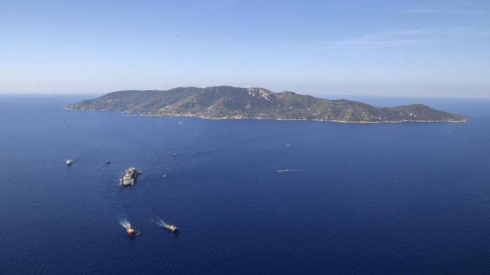 Pour être acheminé jusqu'à Gênes, le Costa Concordia est remorqué par deux bateaux, alors que douze autres embarcations l'escortent.